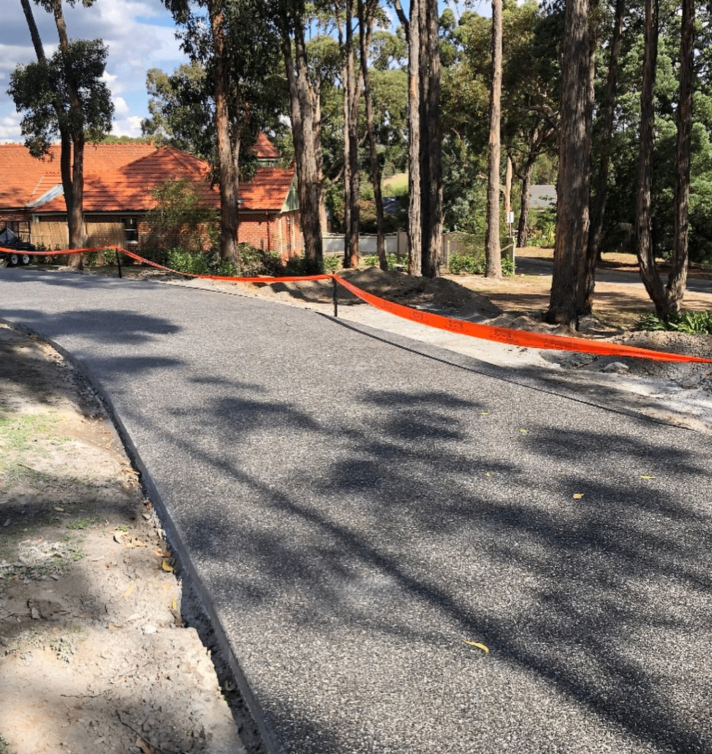 Fresh asphalt driveway winding through gum trees, Ballarat Concreting and Earthworks